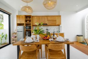 eine Küche mit einem Esstisch aus Holz und Stühlen in der Unterkunft Bali Taoka Villa Tanah Lot in Tanah Lot