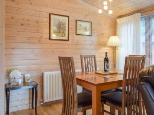 Un comedor con mesa y sillas de madera. en Lodge 5, en Bridgnorth