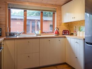 Una cocina con gabinetes blancos y un fregadero y una ventana. en Lodge 5, en Bridgnorth 9 fotos más