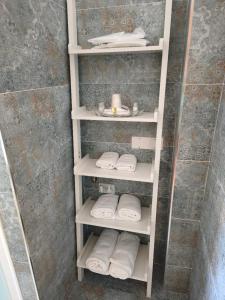 a bathroom with white shelves with towels in a shower at Cà Fortunato in Capriate San Gervasio +7 photos
