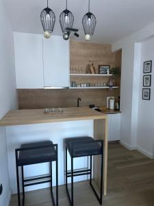 a kitchen with a counter with two black stools at Apartman ISKRA Villa Mont in Jahorina +17 photos