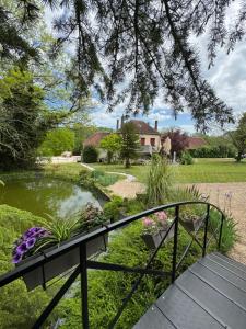 un jardín con un banco y un estanque en Suite avec balnéothérapie, en Montholon