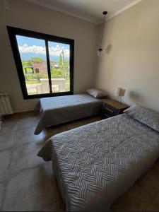 une chambre avec deux lits et une grande fenêtre dans l'établissement Casa Alquiler Amoblada Salta, à Salta