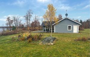 Beautiful Home In Bolmsö With Wifi في Bolmsö: منزل صغير فيه شجرة في حقل