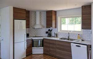 Beautiful Home In Bolmsö With Wifi في Bolmsö: مطبخ مع ثلاجة بيضاء ومغسلة