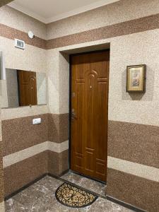 a bathroom with a wooden door and a mirror at Апарт Отель Элин in Svalyava