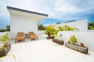 eine Außenterrasse mit Stühlen und Topfpflanzen in der Unterkunft Bali Taoka Villa Tanah Lot in Tanah Lot