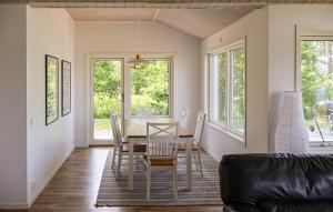 Beautiful Home In Bolmsö With Sauna في Bolmsö: غرفة طعام بها طاولة وكراسي