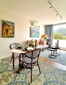 Whale Walk Apartment في هيرمانوس: غرفة معيشة بها طاولة وأريكة