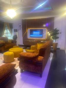 a living room with a couch and a tv at Flexy Short-let in Sagamu