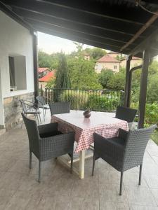 a patio with a table and chairs on a porch at Бялата къща в Слатина in Slatina