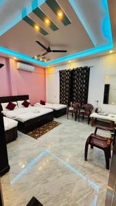 a large room with two beds and a table and chairs at devkritii innn stays in Faizābād