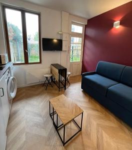 a living room with a blue couch and a table at Charmant studio au cœur du Vieux Bordeaux in Bordeaux