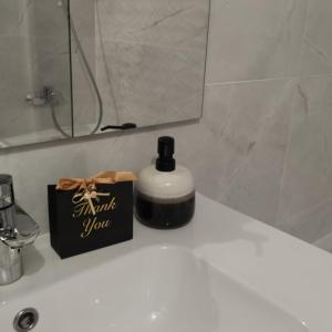 uma garrafa de sabão em cima do lavatório da casa de banho em L'Alexandra em Noisy-le-Grand