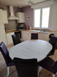 a kitchen with a table and chairs in a kitchen at Au sable fin in Grand-Fort-Philippe