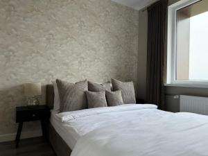 a bedroom with a large white bed and a window at Lake View Apartment in Telšiai