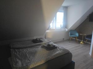 a bedroom with a bed and a window and a chair at Hotel & Restaurant Hasa in Gernrode - Harz