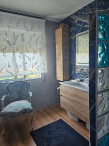 Un baño con bañera, silla y lavabo. en O refuxio do mar, en Oia 70 fotos más