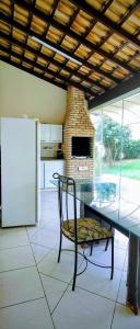 una cucina con tavolo, sedia e frigorifero di Casa Lins 15 pessoas temporada a Lins