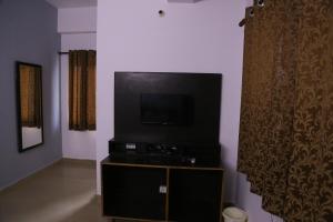 ein Wohnzimmer mit einem Flachbild-TV auf einem Stand in der Unterkunft HOTEL Shooting Karni Range in Faridabad