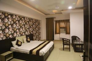 ein Schlafzimmer mit einem Bett und einem Schreibtisch in einem Zimmer in der Unterkunft HOTEL Shooting Karni Range in Faridabad