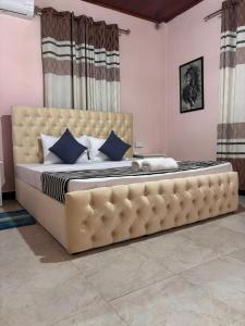 uma cama grande com um sofá grande em um quarto em Peak Lodge em Kandy