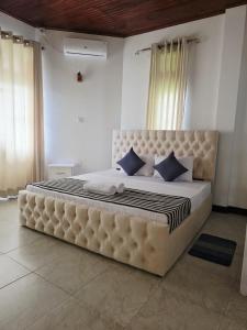 uma cama grande com almofadas azuis num quarto em Peak Lodge em Kandy