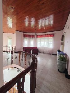 um quarto amplo com um tecto de madeira e janelas em Peak Lodge em Kandy