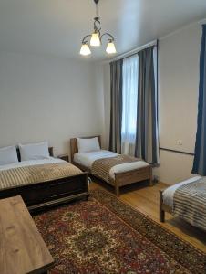 卡兹贝吉Guest house LEGIANA Kazbegi的有两张床和一张地毯的房间