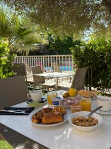 a table with breakfast food on a table with a table sidx sidx at Hôtel Restaurant L' Empereur in Aléria
