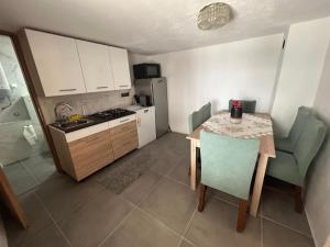 een keuken met een kleine tafel en een keuken met een koelkast bij Kuća za odmor Dramalj in Dramalj