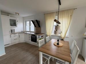 a kitchen with a wooden table and a dining room at Haus Luca Fuhlendorf in Fuhlendorf