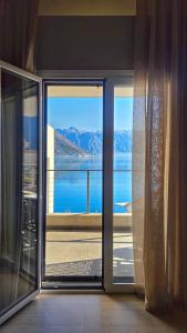 una porta a vetri aperta con vista sull'acqua di Villa Morion a Donji Morinj