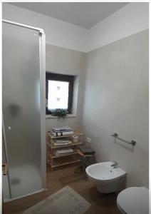 a bathroom with a shower and a toilet and a window at Appartamento GIRASOLE in Trodena
