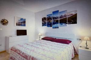 a bedroom with a bed and some paintings on the wall at Appartamento GIRASOLE in Trodena