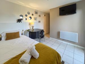 a bedroom with a bed and a desk and a television at MY Tropézienne in Saint-Tropez +6 photos