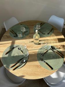 Le CatelierにあるMaison Le Catelierの木製テーブル(緑の皿とグラス付)