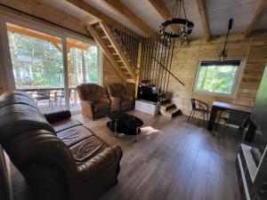 Domek nad jeziorem Wilczyńskim في Świętne: غرفة معيشة بها أريكة وتلفزيون وطاولة