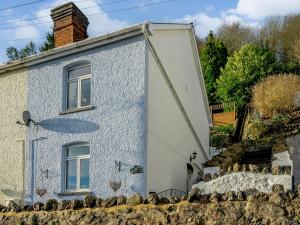 een blauw-wit huis achter een stenen muur bij Valley View in Malvern Wells