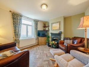 een woonkamer met lederen meubels en een open haard bij Valley View in Malvern Wells