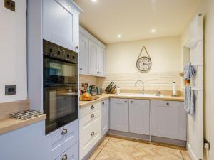 een keuken met witte kasten en een klok aan de muur bij Valley View in Malvern Wells