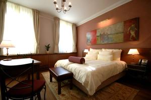 a bedroom with a bed and a desk and a table at Hotel Mitra, Story Hotels in Ptuj