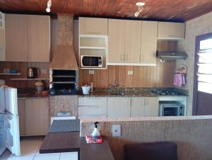 a kitchen with wooden cabinets and a stove top oven at Sobrado 263 in Jaguarão