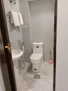 een badkamer met een wit toilet en een wastafel bij شقق المتميزين in Al Madinah