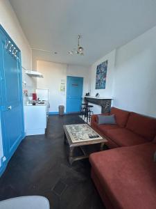 a living room with a red couch and a table at Charmant appartement F2 in Guéret