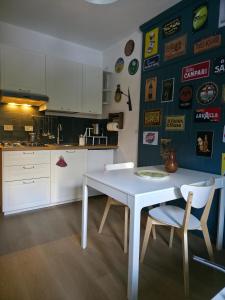 eine Küche mit einem weißen Tisch und Stühlen in der Unterkunft Hope Home Trentino in San Martino di Castrozza + 15 Fotos