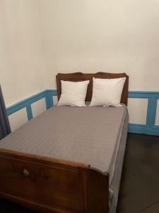 a wooden bed with two pillows on it at Charmant appartement F2 in Guéret