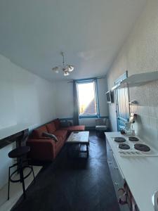 a living room with a couch and a table at Charmant appartement F2 in Guéret