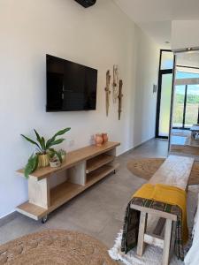 een woonkamer met een flatscreen-tv aan de muur bij Alquimia House in Corrientes