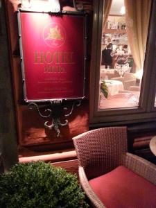 a restaurant with a red sign on the wall and a chair at Hotel Mitra, Story Hotels in Ptuj